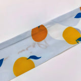 Tørklædebælte med orangeillustrationer i vævet tekstil – model Solira